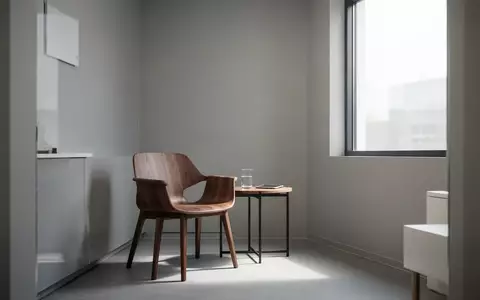 Ein leerer, minimalistischer Therapieraum mit einem einzelnen Stuhl und einem Beistelltisch in hellem, natürlichem Licht. - Foto: über boerse-global.de