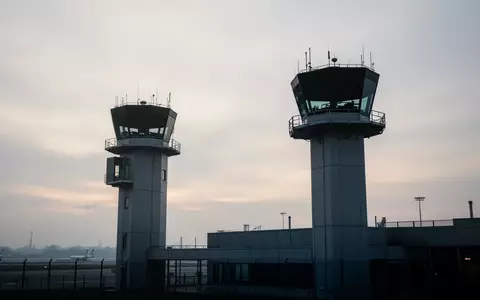 Silhouette eines modernen Flughafenkontrollturms vor einem bewölkten Morgenhimmel. - Foto: über boerse-global.de