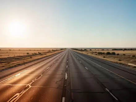 Eine weitläufige Autobahn in Texas bei Sonnenuntergang, die sich durch eine flache Landschaft erstreckt. - Foto: über boerse-global.de