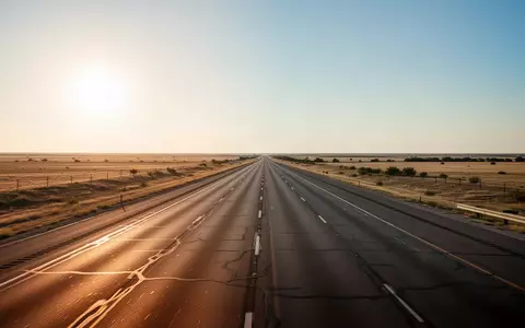 Eine weitläufige Autobahn in Texas bei Sonnenuntergang, die sich durch eine flache Landschaft erstreckt. - Foto: über boerse-global.de