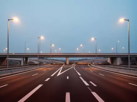 Eine leere Autobahnkreuzung bei Dämmerung, die die moderne Infrastruktur in Europa darstellt. - Foto: über boerse-global.de