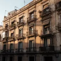 Ein klassisches, mehrstöckiges Wohnhaus mit Balkonen in einer städtischen Wohngegend bei spätem Nachmittagslicht. - Foto: über boerse-global.de