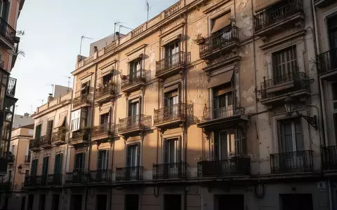 Ein klassisches, mehrstöckiges Wohnhaus mit Balkonen in einer städtischen Wohngegend bei spätem Nachmittagslicht. - Foto: über boerse-global.de