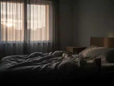 Ein minimalistisch eingerichtetes Schlafzimmer in den frühen Morgenstunden mit sanftem, einfallendem Tageslicht. - Foto: über boerse-global.de