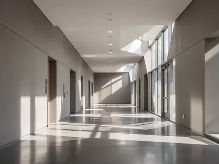 Ein minimalistischer, lichtdurchfluteter Flur in einem modernen öffentlichen Gebäude mit poliertem Betonboden. - Foto: über boerse-global.de