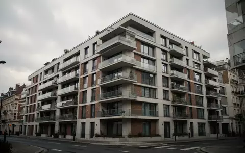 Ein modernes, mehrstöckiges Wohngebäude mit Balkonen vor einem bewölkten Himmel. - Foto: über boerse-global.de