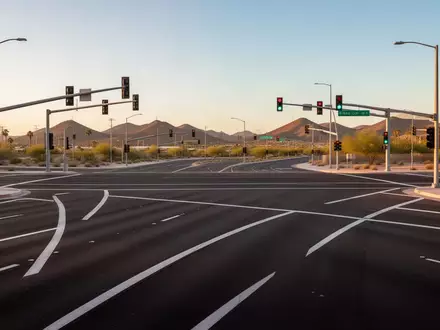 Eine moderne, leere Straßenkreuzung in einer US-Metropole bei Sonnenuntergang mit klar markierten Fahrspuren. - Foto: über boerse-global.de