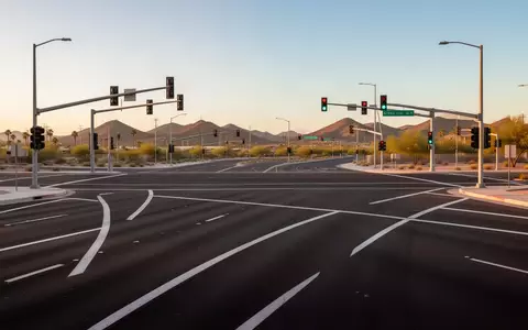 Eine moderne, leere Straßenkreuzung in einer US-Metropole bei Sonnenuntergang mit klar markierten Fahrspuren. - Foto: über boerse-global.de