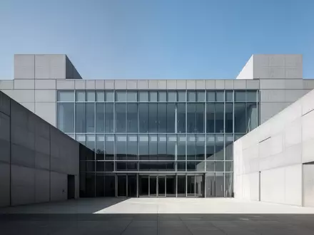 Modernes Verwaltungsgebäude aus Glas und Beton vor blauem Himmel. - Foto: über boerse-global.de