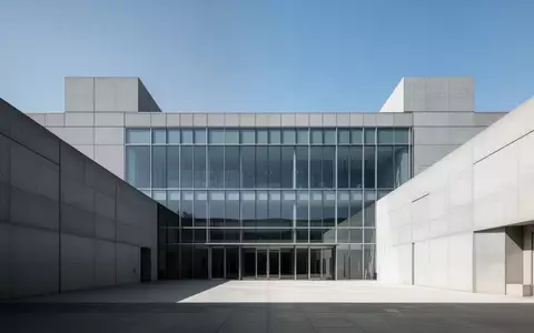 Modernes Verwaltungsgebäude aus Glas und Beton vor blauem Himmel. - Foto: über boerse-global.de