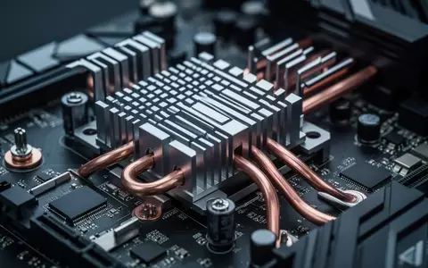 Detailaufnahme einer modernen Computer-Hauptplatine mit metallischen Kühlkörpern und feinen elektronischen Komponenten. - Foto: über boerse-global.de