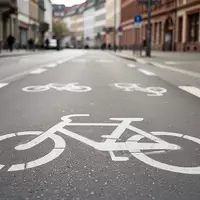 Leerer Radweg in einer deutschen Stadt mit aufgemaltem Fahrrad- und E-Scooter-Symbol bei Tageslicht. - Foto: über boerse-global.de