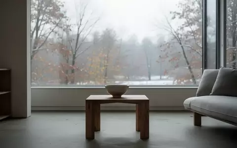 Ein minimalistisch eingerichtetes, leeres Wohnzimmer an einem trüben Herbsttag, das eine Atmosphäre der Zurückhaltung vermittelt. - Foto: über boerse-global.de