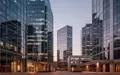 Moderne Glasfassaden eines Finanzviertels bei Dämmerung, die wirtschaftliche Dynamik und urbane Architektur symbolisieren. - Foto: über boerse-global.de