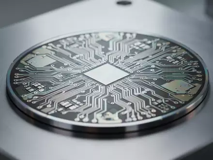 Nahaufnahme eines Silizium-Wafers mit komplexen Schaltkreisstrukturen auf einer metallischen Oberfläche in einem Labor. - Foto: über boerse-global.de