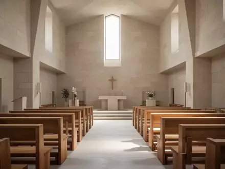 Ein minimalistischer, lichtdurchfluteter Kircheninnenraum mit schlichten Holzbänken und Steinwänden. - Foto: über boerse-global.de