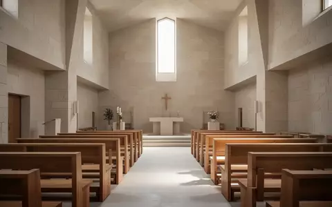 Ein minimalistischer, lichtdurchfluteter Kircheninnenraum mit schlichten Holzbänken und Steinwänden. - Foto: über boerse-global.de