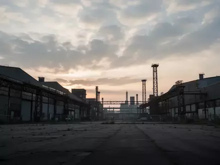 Weite Ansicht eines leeren deutschen Industrieparks bei Dämmerung mit Fabrikhallen und Stahlkonstruktionen. - Foto: über boerse-global.de
