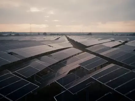 Reihen von Photovoltaik-Modulen in einem Solarpark bei bewölktem Himmel. - Foto: über boerse-global.de