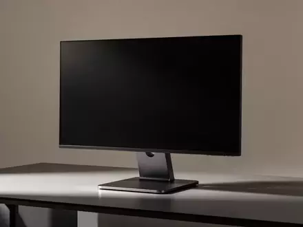 Ein minimalistischer Arbeitsbereich mit einem leeren, hochwertigen Monitorständer vor einem neutralen, sanft beleuchteten Hintergrund. - Foto: über boerse-global.de