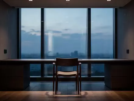 Ein minimalistischer, leerer Arbeitsplatz in der Abenddämmerung mit Blick durch ein Fenster. - Foto: über boerse-global.de