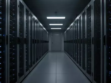 Dunkler Serverraum mit langen Reihen technischer Infrastruktur in einem sterilen, modernen Gebäude. - Foto: über boerse-global.de