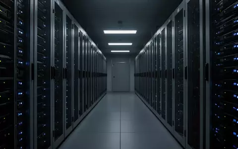 Dunkler Serverraum mit langen Reihen technischer Infrastruktur in einem sterilen, modernen Gebäude. - Foto: über boerse-global.de