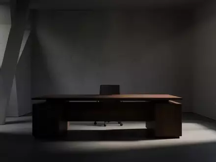 Ein minimalistisch eingerichtetes, dunkles BĂŒro mit einem leeren Schreibtisch und schattenhaften LichtverhĂ€ltnissen. - Foto: ĂŒber boerse-global.de