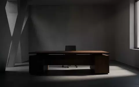Ein minimalistisch eingerichtetes, dunkles Büro mit einem leeren Schreibtisch und schattenhaften Lichtverhältnissen. - Foto: über boerse-global.de