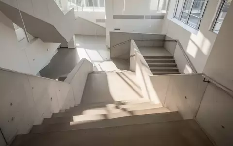 Ein minimalistisches Treppenhaus mit hellem, natürlichem Licht und Architektur aus Beton, die Bewegung im Alltag symbolisiert. - Foto: über boerse-global.de