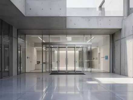 Moderner Eingangsbereich eines Gesundheitsgebäudes mit Glasfront bei Tageslicht. - Foto: über boerse-global.de