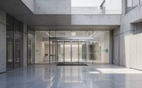 Moderner Eingangsbereich eines Gesundheitsgebäudes mit Glasfront bei Tageslicht. - Foto: über boerse-global.de