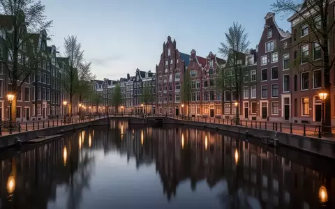 Amsterdamer Grachten bei Dämmerung mit historischer Architektur und Spiegelungen im Wasser - Foto: über boerse-global.de