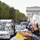 Papst Leo winkt der Menschenmenge auf den Champs-Élysées. - Bild: Emma Da Silva/AP/dpa