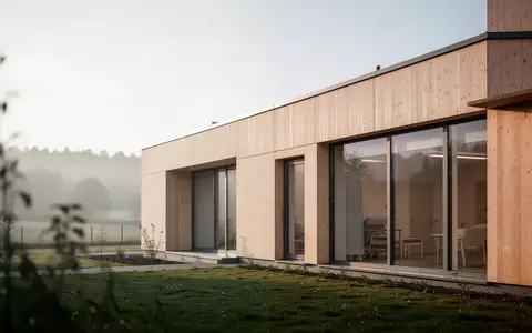 Modernes Pflegeheimgebäude mit großen Fensterfronten und heller Holzfassade in einer ruhigen Umgebung. - Foto: über boerse-global.de