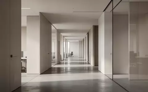 Ein minimalistischer, leerer Flur in einem modernen Bürogebäude mit hellem Tageslicht und klaren architektonischen Linien. - Foto: über boerse-global.de