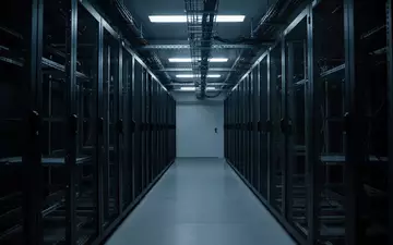 Ein dunkler, minimalistischer Serverraum mit leeren Serverschränken und kühler blauer Beleuchtung. - Foto: über boerse-global.de