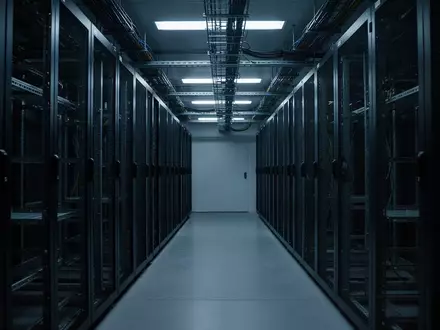 Ein dunkler, minimalistischer Serverraum mit leeren Serverschränken und kühler blauer Beleuchtung. - Foto: über boerse-global.de