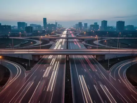 Eine nächtliche Autobahnkreuzung mit fließenden Lichtspuren und moderner Infrastruktur. - Foto: über boerse-global.de