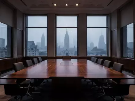 Ein leerer Konferenztisch in einem schlichten, architektonisch gestalteten Regierungsgebäude bei Dämmerung. - Foto: über boerse-global.de