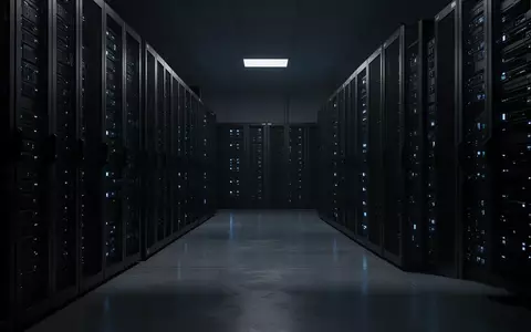 Dunkler Serverraum mit schimmernden Statusleuchten an den Gehäusen. - Foto: über boerse-global.de