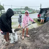 In Hawaii füllen Menschen Sandsäcke, um ihre Häuser vor den Auswirkungen von «Nolo» zu schützen. - Foto: Eugene Garcia/AP/dpa