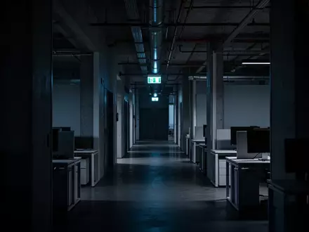 Ein leeres, dunkles Bürogebäude bei Dämmerung, das die Unsicherheit und das Risiko digitaler Bedrohungen symbolisiert. - Foto: über boerse-global.de