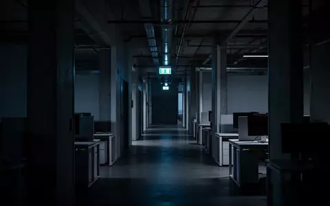 Ein leeres, dunkles Bürogebäude bei Dämmerung, das die Unsicherheit und das Risiko digitaler Bedrohungen symbolisiert. - Foto: über boerse-global.de