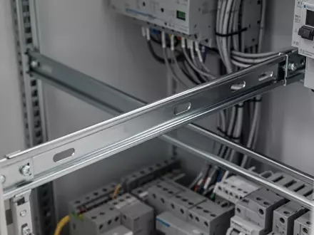 Eine leere Hutschiene in einem modernen industriellen Schaltschrank mit ordentlicher Verkabelung. - Foto: über boerse-global.de