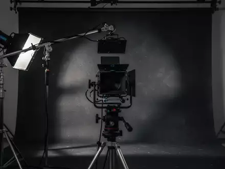 Ein professionelles Film-Licht-Setup in einem abgedunkelten Studio, das den Fokus auf Schärfentiefe und Lichtführung legt. - Foto: über boerse-global.de