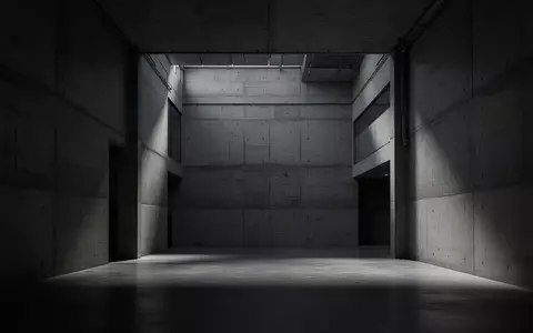 Ein minimalistischer, leerer Innenraum eines modernen Industriegebäudes mit Betonwänden und tiefen Schatten. - Foto: über boerse-global.de
