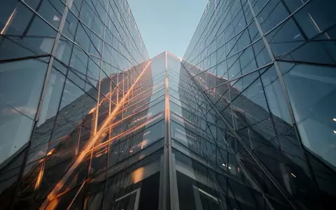 Die Glasfassade eines modernen Wolkenkratzers spiegelt den blauen Himmel wider. - Foto: über boerse-global.de