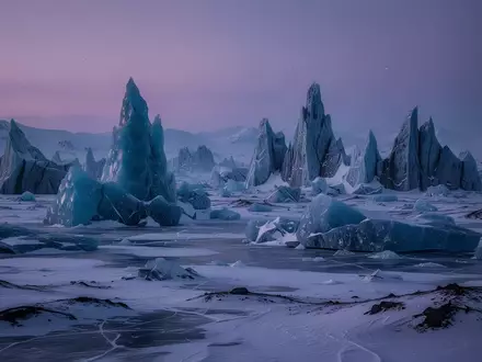 Eine weite, arktische Tundra mit zerklüfteten, kristallinen Eisformationen unter einem dämmrigen, violetten Himmel. - Foto: über boerse-global.de