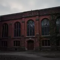 Ein leeres, historisches Backsteingebäude auf einem Universitätscampus in der Abenddämmerung. - Foto: über boerse-global.de
